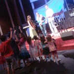 Pastor with his wife, Cheryl (holding Kylah) and Hannah (13) - Cheryl and Hannah have on their scarves. And on the floor in front with her hand raised and looking over her shoulder is Alayna wearing her scarf